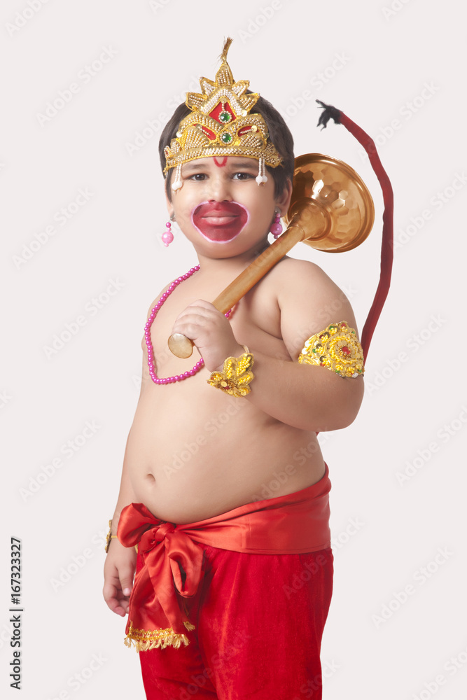Portrait of confident boy dressed as God Hanuman against white background