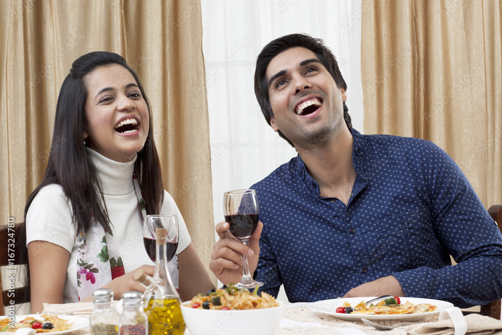 Cheerful young couple enjoying the meal at restaurant Cheerful young couple enjoying the meal at restaurant