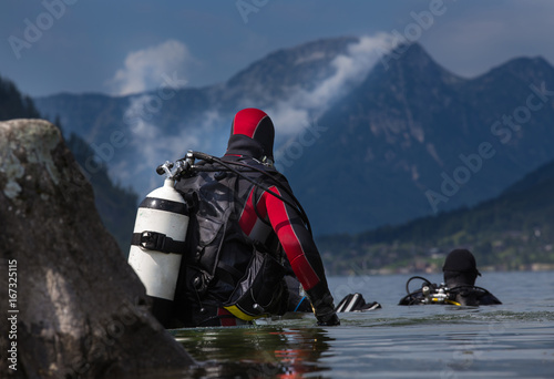 Divers entering water in mountain lake
