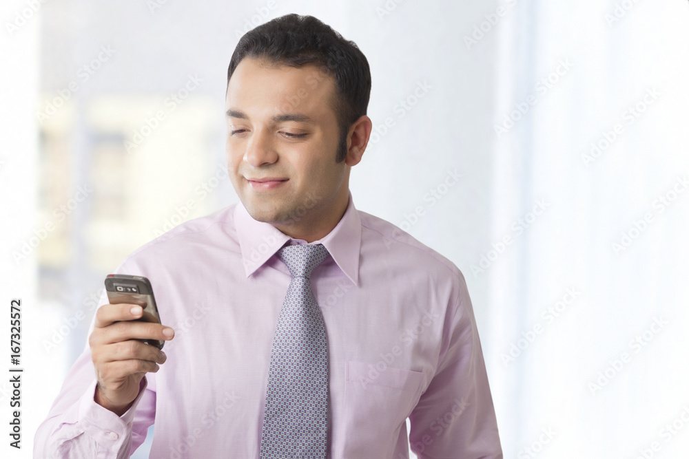Business executive reading an sms on a mobile phone Business executive reading an sms on a mobile phone