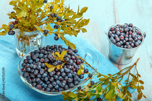 Fresh forest berry, blueberries in a glass plate on a wooden table photo