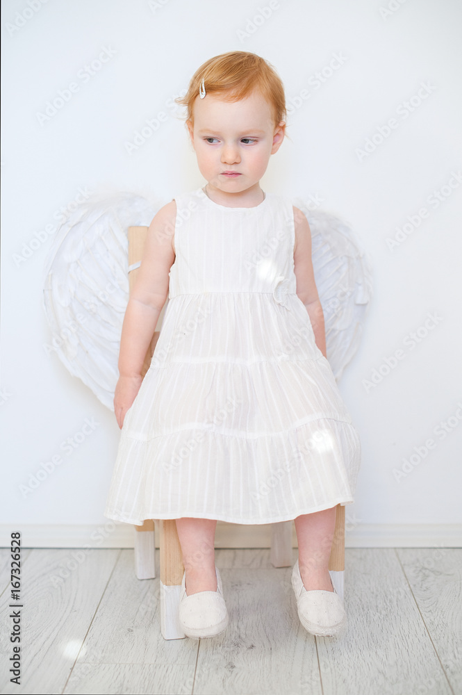A sad angel sits on a chair A sad angel sits on a chair