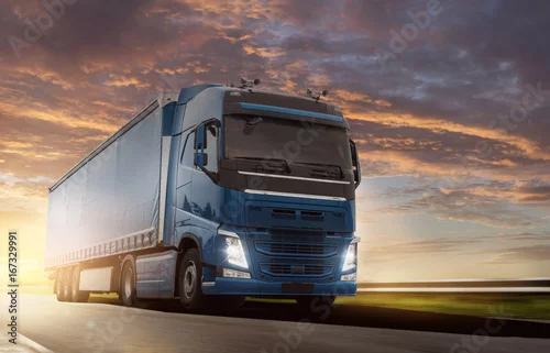 Obraz Ciężarówka jedzie przy wschodem słońca na wiejskiej drodze