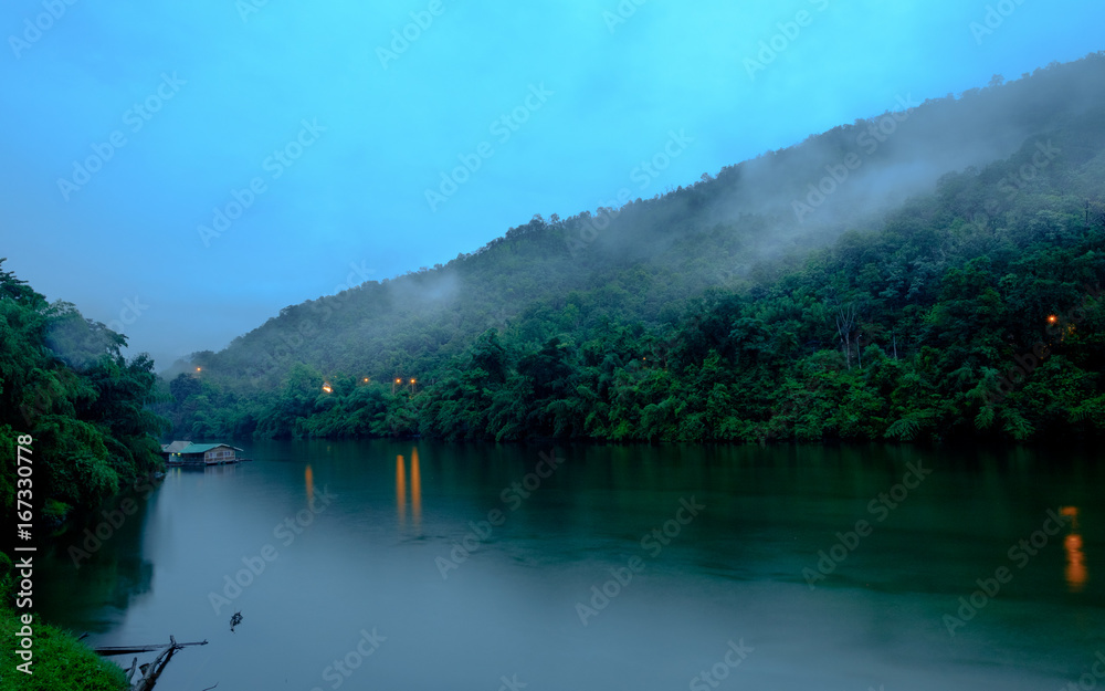 Mountain forest with fog and houseboat on kwai river landscape on rain in kanchanaburi, Thailand. Natural concept