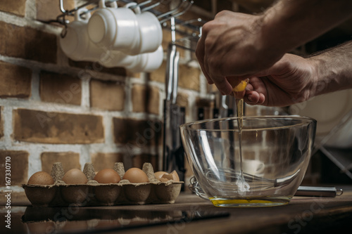 partial view of young man preparing omelette for breakfast in kitchen at home