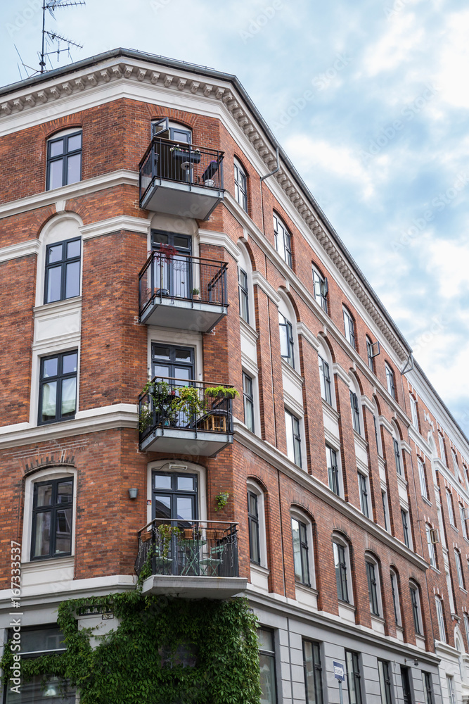 Facade of red brick Building with Balconies, Copenhagen, Europe
