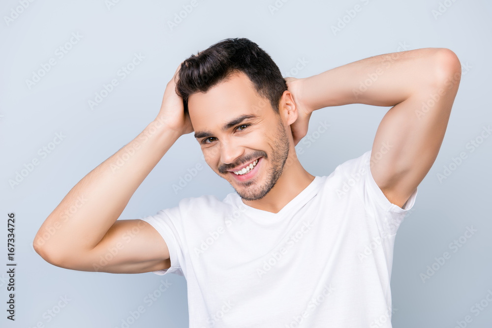 Confident smiling handsome young man in white t shirt. standing on the pure background, fixing his perfect hairstyle. So hot and attractive, harsh and fashionable Confident smiling handsome young man in white t shirt. standing on the pure background, fixing his perfect hairstyle. So hot and attractive, harsh and fashionable