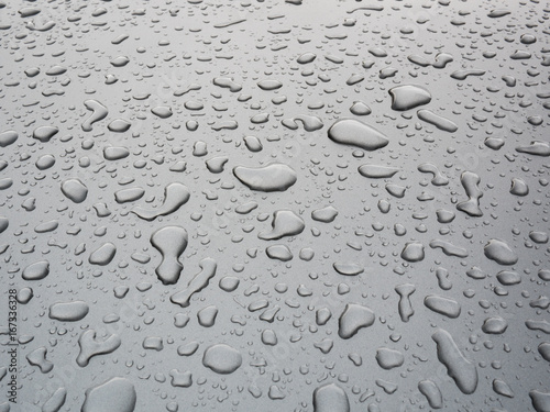 Closeup drop of water on the car with grey background after rain, nature background