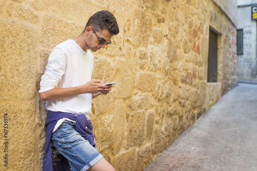 portrait of young smiling with the mobile phone in the city