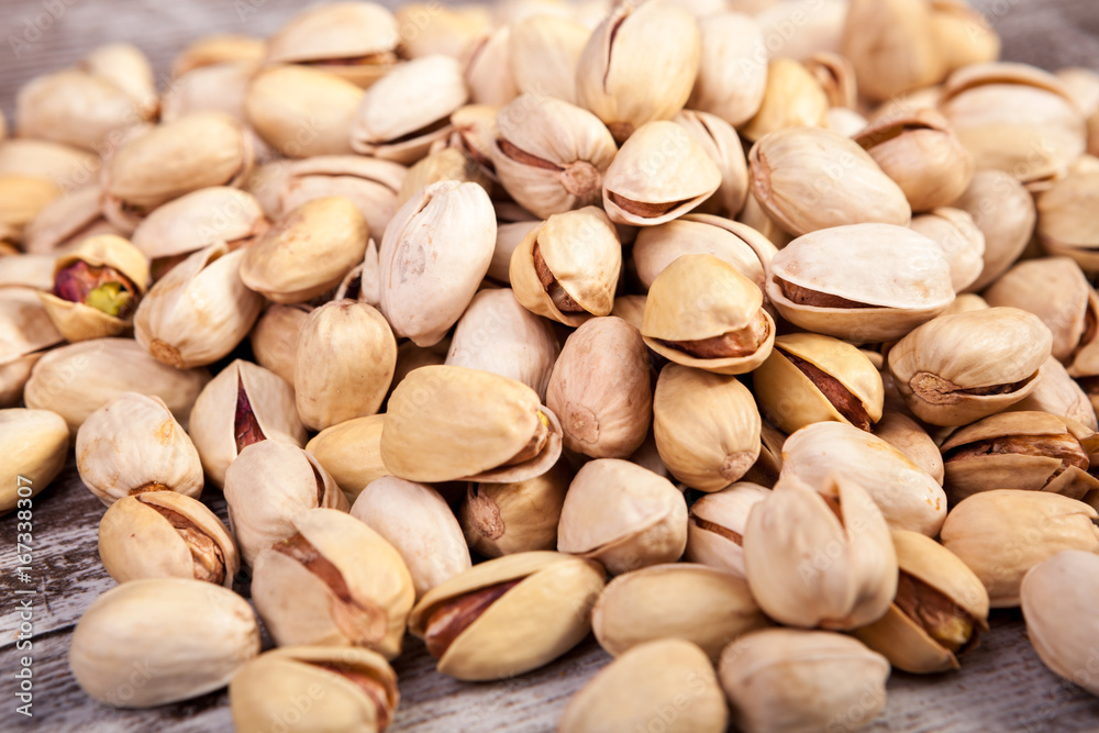 Close up of Pistachios on wooden background in studio photo. Healthy delicious snacks