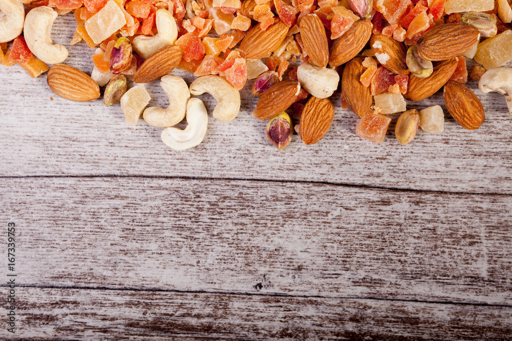 Healthy different type of nuts and sweet on wooden background in studio photo