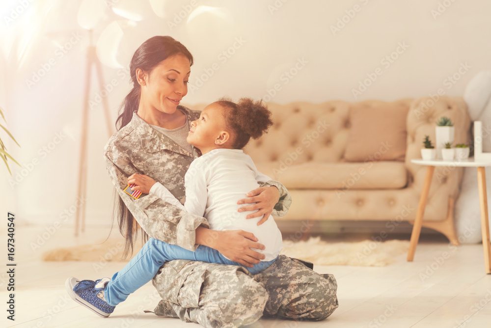 Lovely little girl sitting in the lap of her mother-soldier Lovely little girl sitting in the lap of her mother-soldier