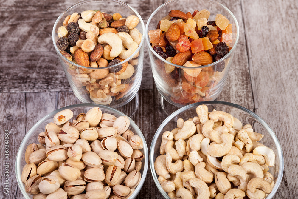 Healthy mix of dried nuts and sweets in was glass on wooden background in studio photo Healthy mix of dried nuts and sweets in was glass on wooden background in studio photo