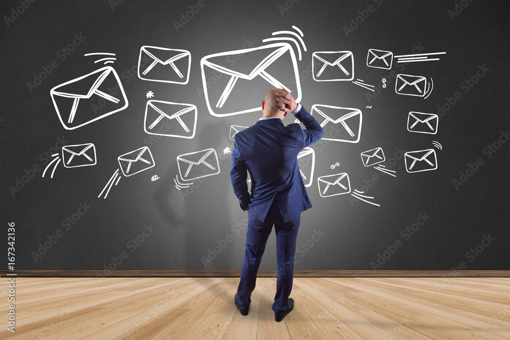 Businessman in front of a wall reading email interface - Technology concept Businessman in front of a wall reading email interface - Technology concept