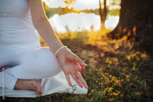  hand of a young woman are folded in a special way into a yoga mudra