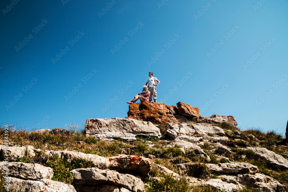 Young couple sitting on the cliff