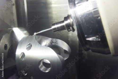 The 5-axis CNC milling machine cutting the automotive part with the ball end-mill tool.Hi-technology machining concept.