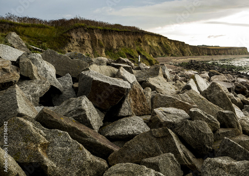 Granite boulders heaped on a beach as Sea Defences. Gives the impression of a masive barrier or a difficult way ahead, photo
