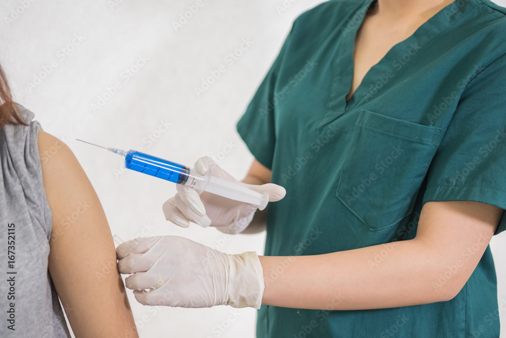 Close-up hands,nurses are vaccinations to patients using the syringe.Doctor vaccinating women in hospital.Are treated by the use of sterile injectable upper arm. injection, Close-up hands,nurses are vaccinations to patients using the syringe.Doctor vaccinating women in hospital.Are treated by the use of sterile injectable upper arm. injection,