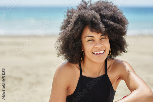 Young pretty afro american woman on beach smiling