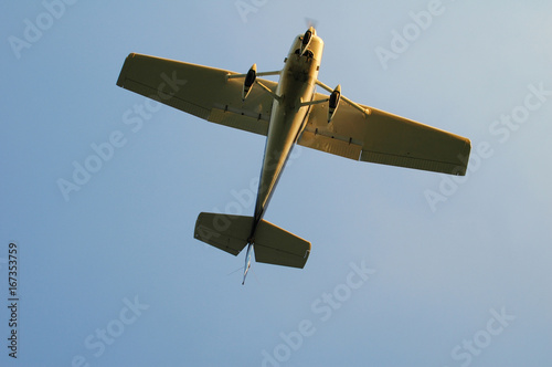 single engine white monoplane ready for landing seen from below photo