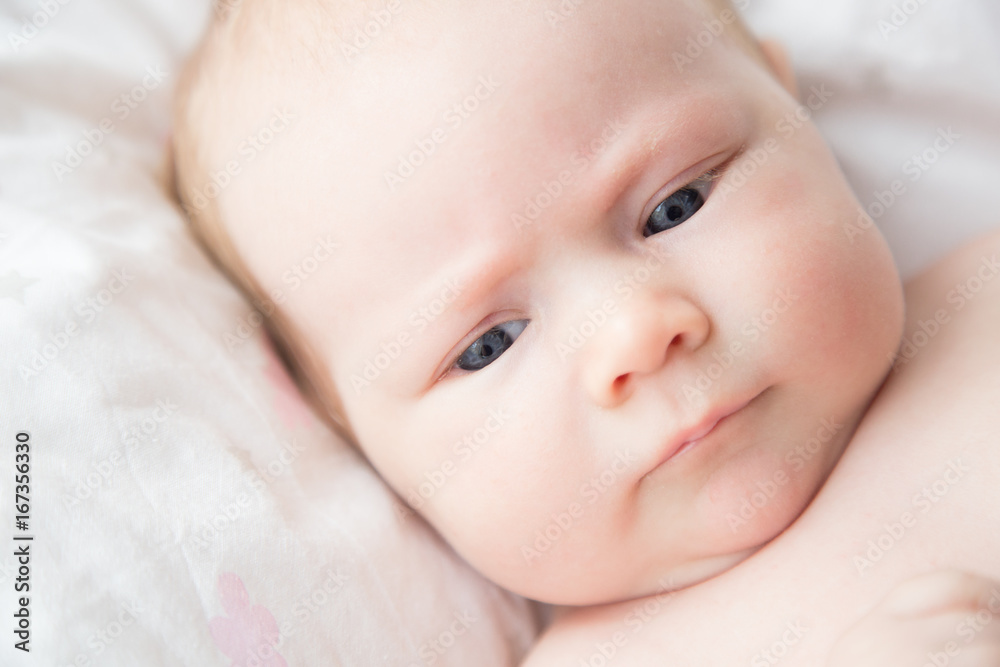 portrait of a sleepy newborn girl with blue eyes