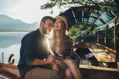 Принти на полотні Two stylishly dressed young kiss while sitting on the boat