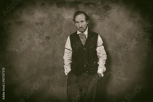 Classic wet plate photo of vintage 1900 western man leaning against wall.