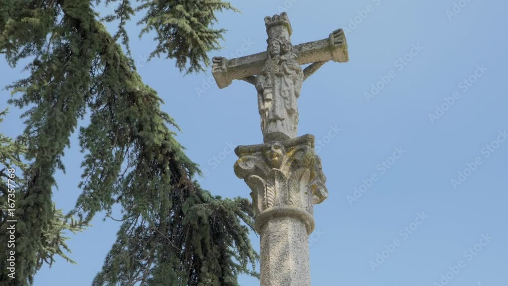 Stone cross in the garden of a small church of the seventeenth century Stone cross in the garden of a small church of the seventeenth century