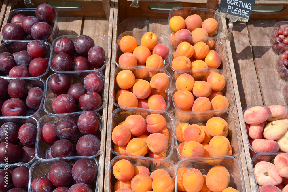 Punnets of apricots plums and peaches outside greengrocers