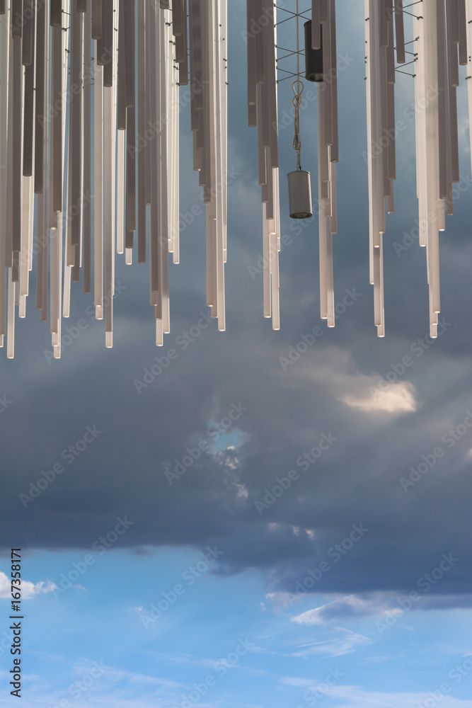 Hanging Vertical Group of Silver Plastic Pipe and Blue Sky in Background Hanging Vertical Group of Silver Plastic Pipe and Blue Sky in Background