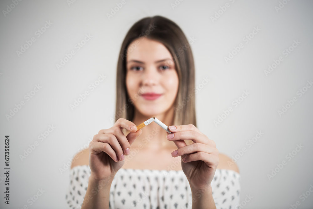 woman holding a broken cigarette,quit smoking concept. woman holding a broken cigarette,quit smoking concept.