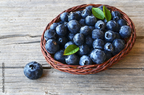 Freshly picked blueberries in a basket on old wooden background.Fresh blueberries with green leaves on rustic table. Blueberry.
Bilberry.Healthy eating,diet and nutrition concept.