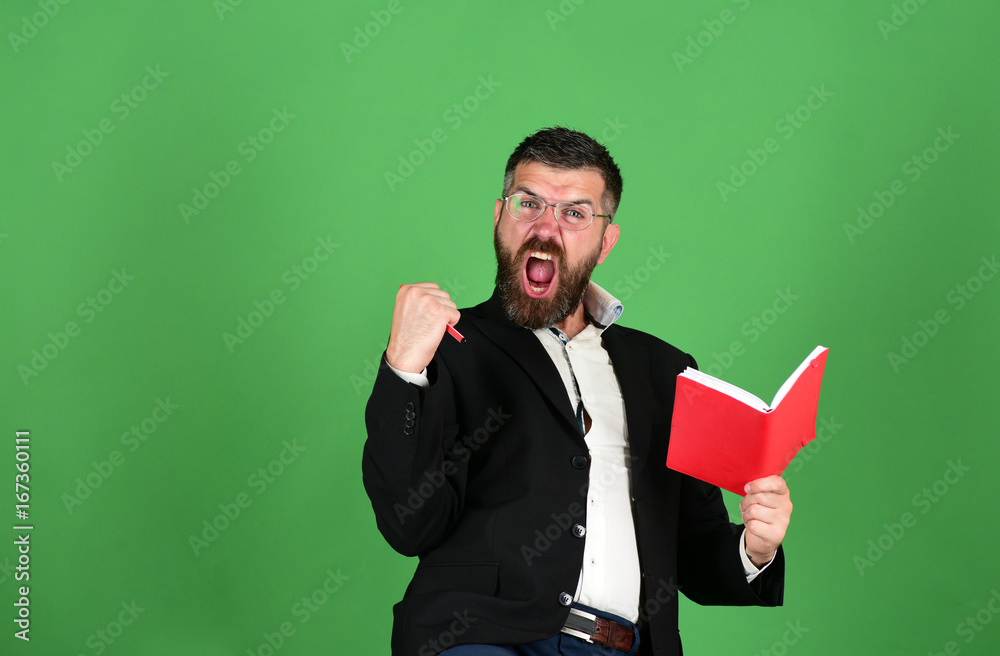 Textbook in red color in guys hands on green background