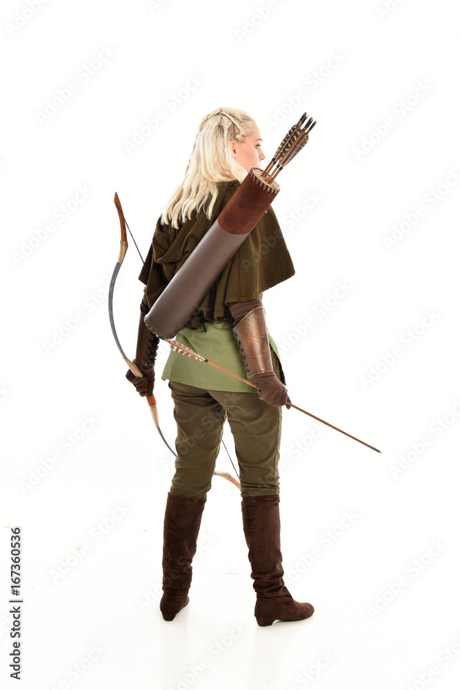 full length portrait of a blonde girl wearing green and brown medieval costume, holding a bow and arrow. isolated on white background. full length portrait of a blonde girl wearing green and brown medieval costume, holding a bow and arrow. isolated on white background.