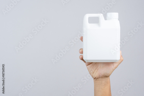 Hand holding 1000 cc, a liter plastic bottle or 0.26 gallon capacity for containing fertilizer or industrial liquid