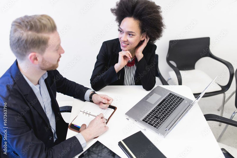 Multiracial business man and woman working together in modern office. Multiracial business man and woman working together in modern office.