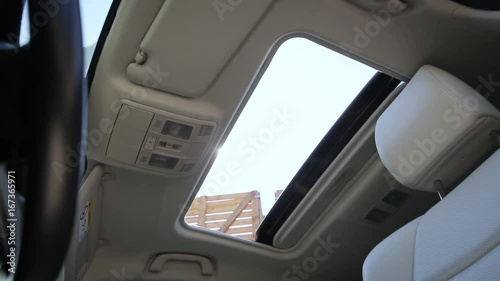 Interior view of car sunroof opening, tan interior. photo