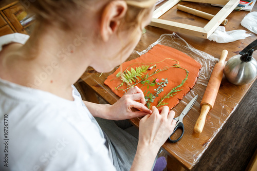 Woman making botanical plaster artwork in her home studio. photo