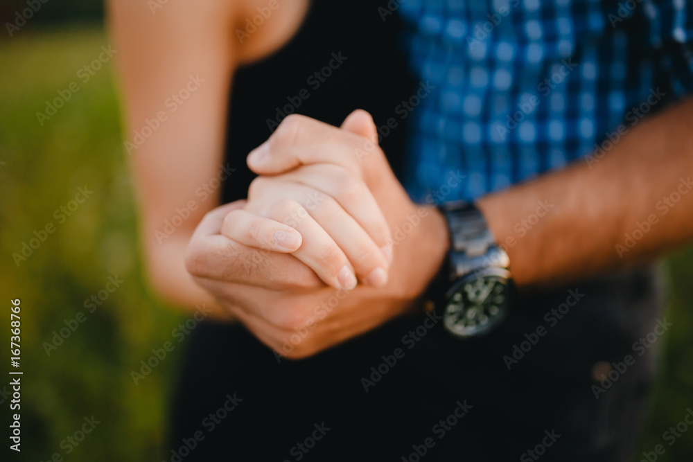 Lovers hold on to each other's hand, touch and contact between a guy and a girl, on hand of a guy's watch. The concept of feelings Lovers hold on to each other's hand, touch and contact between a guy and a girl, on hand of a guy's watch. The concept of feelings