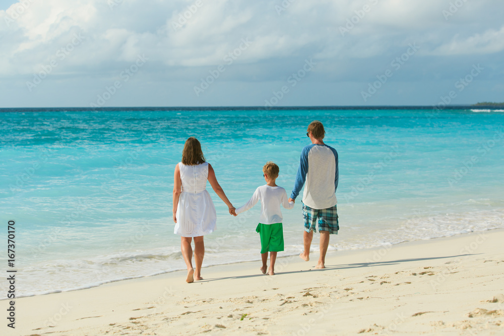 family with kid walking on beach
