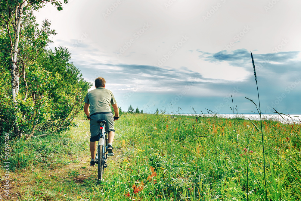 a young man rides a Bicycle in the woods