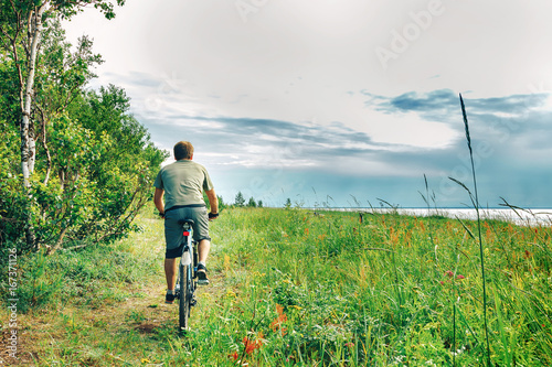 Obraz na płótnie a young man rides a Bicycle in the woods w salonie