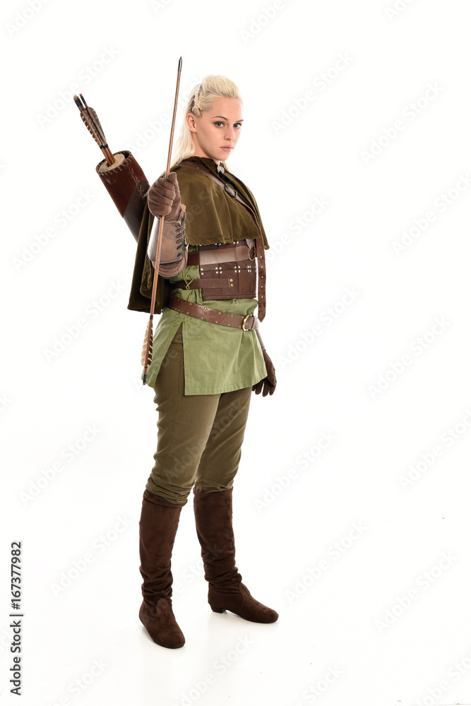 full length portrait of a blonde girl wearing green and brown medieval costume, holding a bow and arrow. isolated on white background. full length portrait of a blonde girl wearing green and brown medieval costume, holding a bow and arrow. isolated on white background.