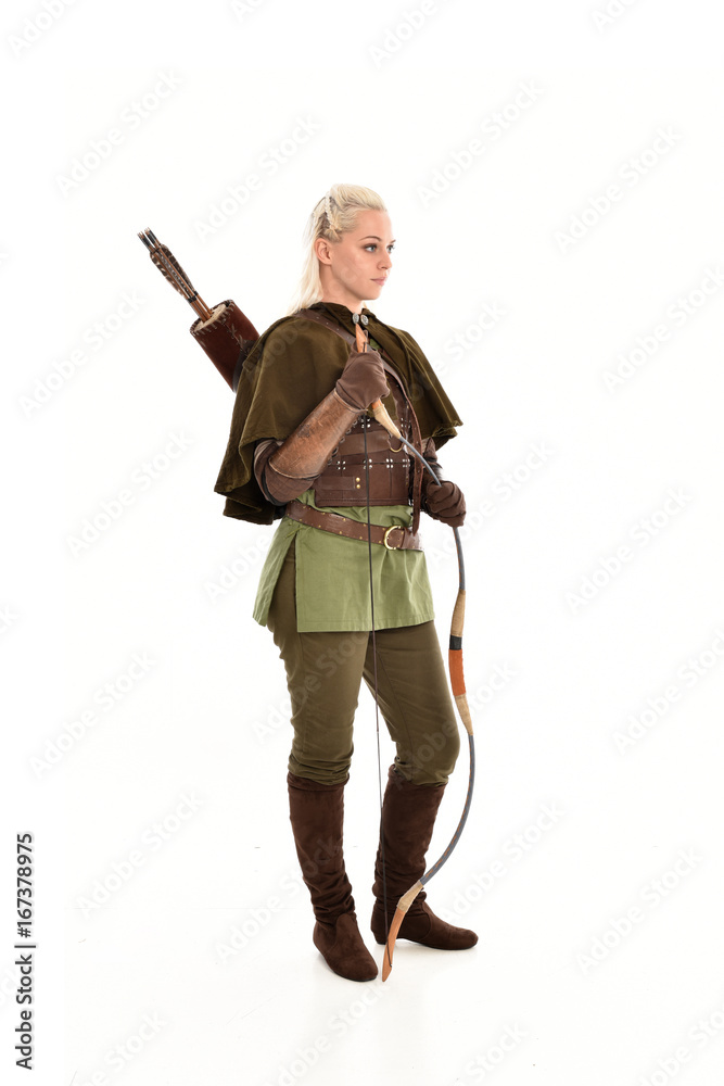 full length portrait of a blonde girl wearing green and brown medieval costume, holding a bow and arrow. isolated on white background. full length portrait of a blonde girl wearing green and brown medieval costume, holding a bow and arrow. isolated on white background.