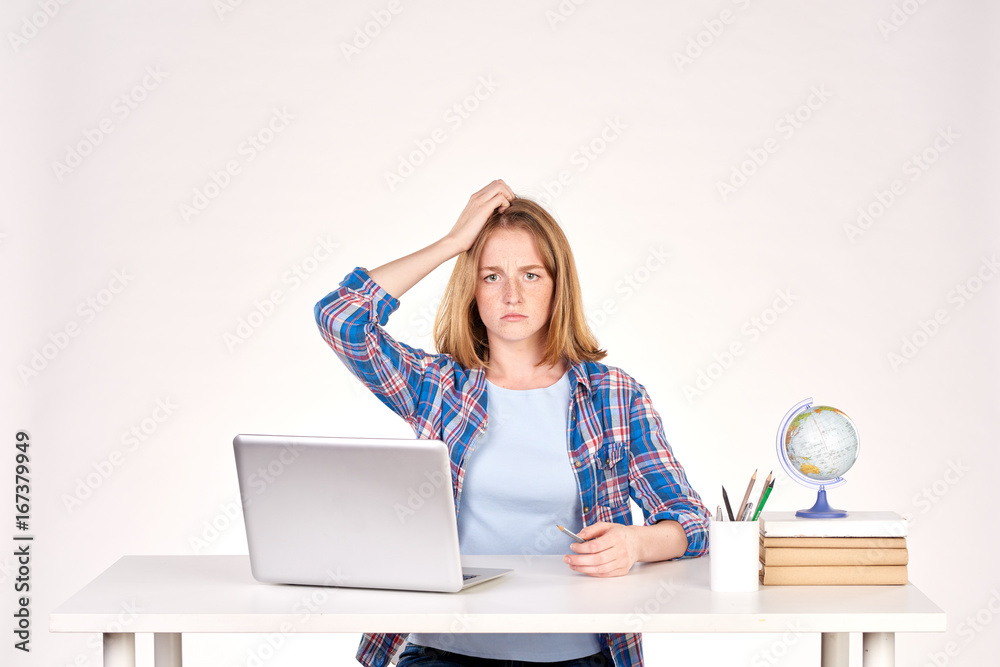 Portrait of teenage red-haired student sitting at desk Portrait of teenage red-haired student sitting at desk