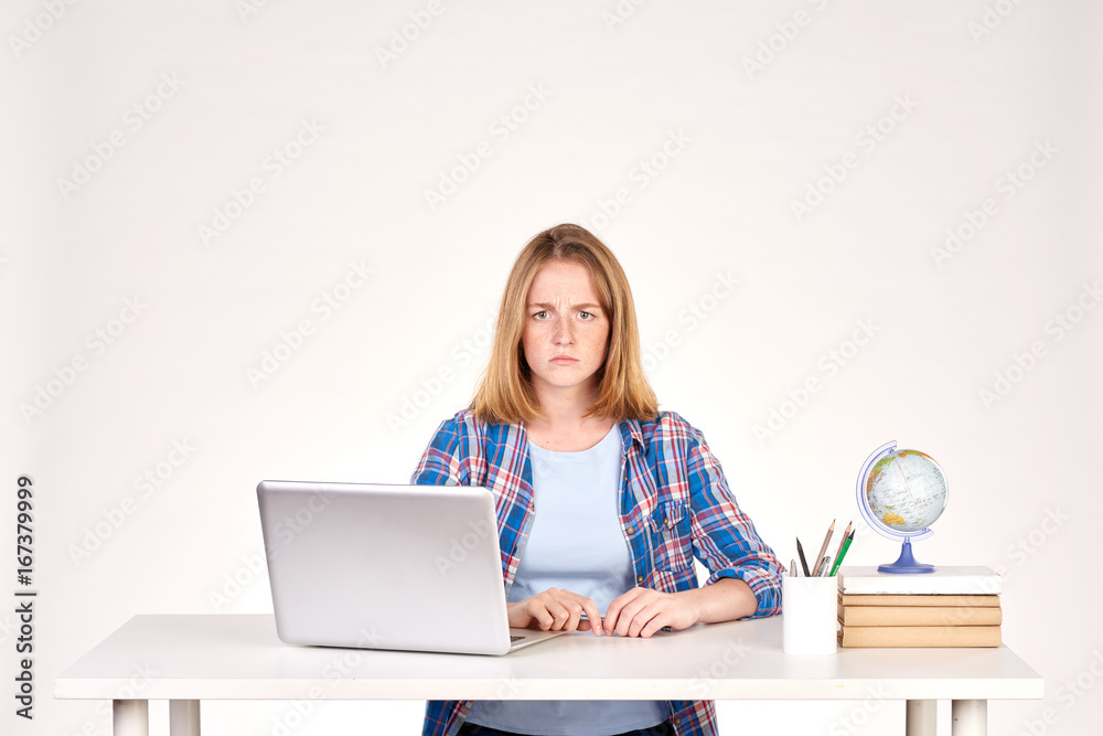 Portrait of teenage red-haired student sitting at desk Portrait of teenage red-haired student sitting at desk