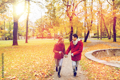 happy young couple running in autumn park
