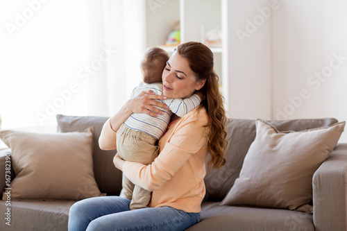 happy young mother hugging little baby at home