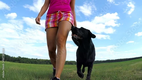 Woman walk with black dog in the park.